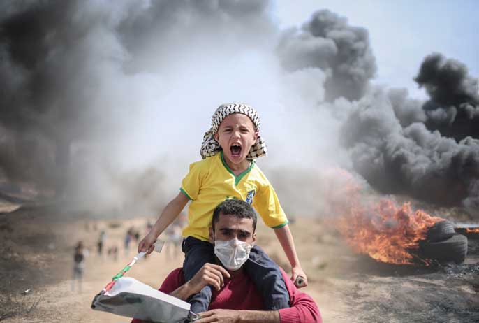 Gaza, Palestine, June. 2019. Palestinian father and son protesting at the borders between Gaza strip and Israel