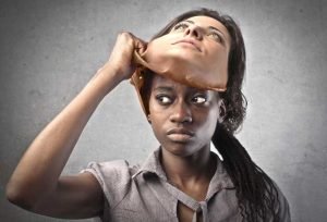 Une jeune femme africaine enlève un masque d'une femme caucasienne