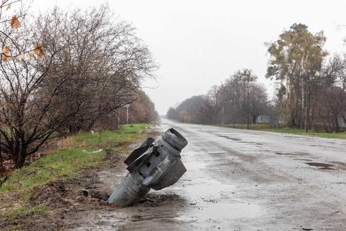 Une fusée non explosée des troupes d'occupation russes sort de la route